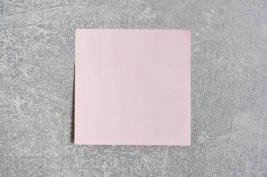 Pink paper sticker for writing notes is pasted concrete wall
