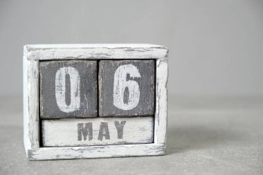 May 6, Wooden desktop calendar gray background.Spring month depicted on cubes.Place for your ideas