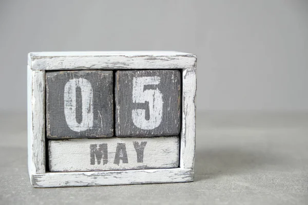 May 5, Wooden desktop calendar gray background.Spring month depicted on cubes.Place for your ideas
