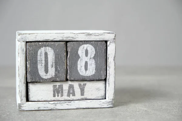 May 8, Wooden desktop calendar gray background.Spring month depicted on cubes.Place for your ideas