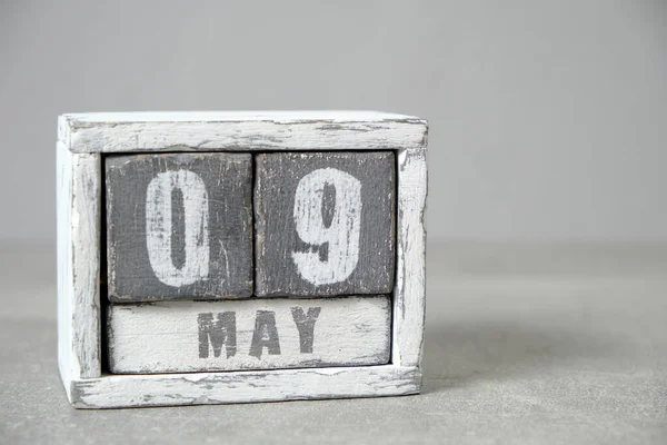 May 9, Wooden desktop calendar gray background.Spring month depicted on cubes.Place for your ideas