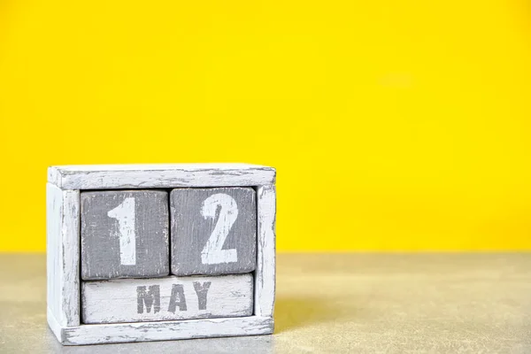 May 12 calendar made wooden cubes yellow background.With an empty space for your text.International Day nurse