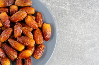 Dates plate gray background.Edible fruits date palm