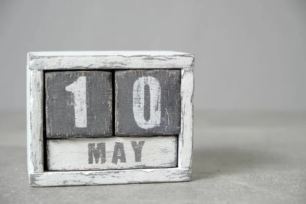 May 10 calendar made wooden cubes gray background.With an empty space for your text