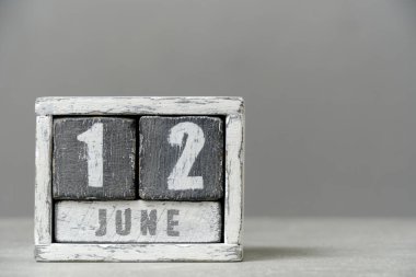 12 Haziran takvimi, ahşap küpler, gri arkaplan. Metnin için boş bir yer var.
