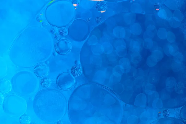 Abstract blue background in macro magnification.With oil water circles