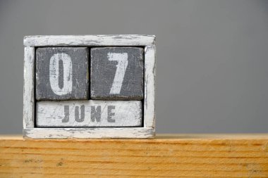 Gri arka planda rafta duran ahşap küplerden yapılmış Haziran 07 takvimi. Mesajınız için boş bir alan. Gıda Güvenliği Günü