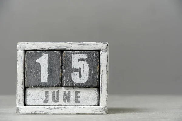 Calendar for June 15, made wooden cubes, on gray background.With an empty space for your text