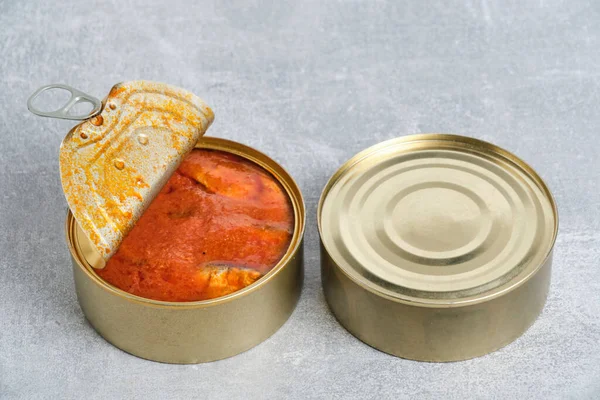灰色のコンクリートの背景にトマトの魚とオープン錫缶 — ストック写真