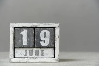 19 Haziran takvimi, tahta küpler, gri arka plan. Mesajın için boş bir yer. Hokkabazlık günü.