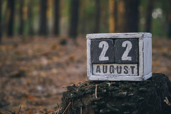 August 22 summer month, wooden calendar with date and month in forest.Flag Day of Russia