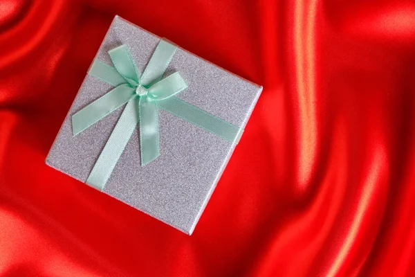 Coffret Cadeau Argent Avec Ruban Vert Noeud Sur Tissu Rouge — Photo