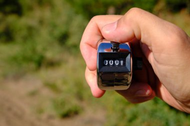 Elinizdeki yeşil arkaplandaki doğru sayım için manuel mekanik sayaç