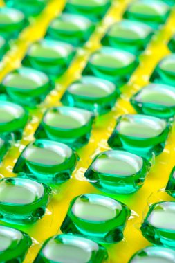 Sarı zeminde yeşili yıkamak için arka plan kapsülleri