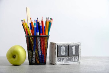 Yeşil elma, kalem ve cetvelli düzenleyici, kırtasiye standı ve takvim tarihi 01 Eylül