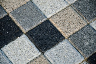 Damalı mozaik, çok renkli kaldırım levhaları yakın plan, gri ve bej tonlarda.