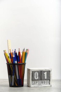 Kalem ve cetvelli düzenleyici, kırtasiye standı ve 01 Eylül tarihli ahşap takvim