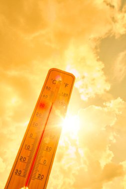 Arkaplanda termometre, yaz sarısı güneş. Sıcak hava ve yüksek hava sıcaklığı.
