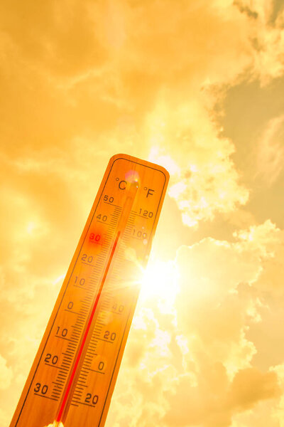 Thermometer against background hot, summer yellow sun.Hot weather and high air temperature