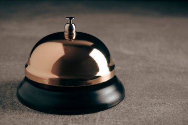 Desktop Call Bell altın renginde beton arka plan. Otel resepsiyonu, retro tarzı, klasik.
