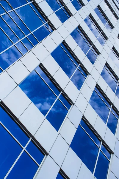 Futuristic building background with reflecting blue sky in facade