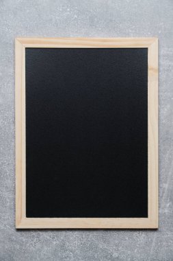 Gri beton duvara karşı tahta çerçeveli notlar için siyah karatahta