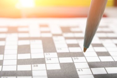 Ballpoint pen on background crossword puzzle sheet in the contoured sunlight clipart