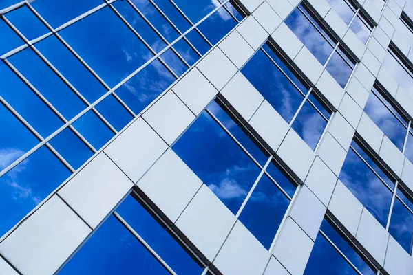 Futuristic building background with reflecting blue sky in facade