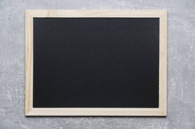 Gri beton duvara karşı tahta çerçeveli notlar için siyah karatahta