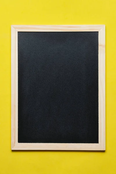 stock image Black blackboard for notes in wooden frame yellow background