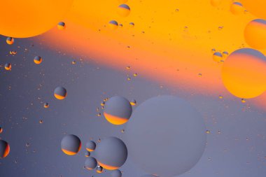 Soyut turuncu gri arkaplan, su yüzeyinde yağ daireleri var.
