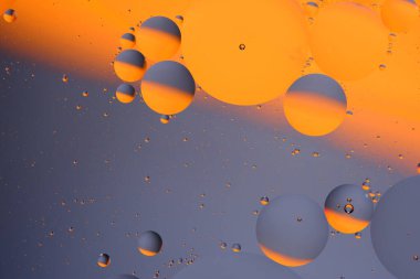 Soyut turuncu gri arkaplan, su yüzeyinde yağ daireleri var.