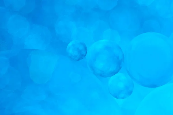 Macro photo with circles oil droplets water surface. Abstract blue background with oil bubbles
