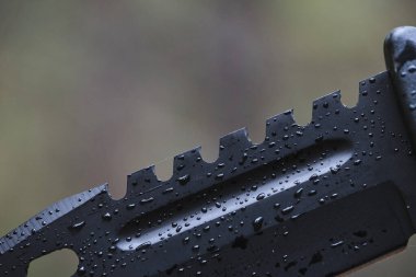 Yağmur damlalarında keskin siyah bıçak.