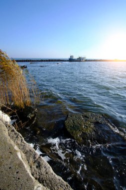 Terk edilmiş eski paslı gemi iskeleye demirlemiş.