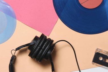 Arka plan, eski vinil plaklar, kulaklıklar ve bir ses kaseti.