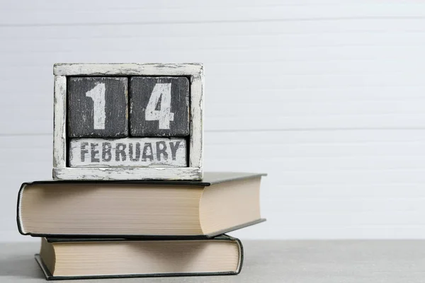 2月14日的日历和白底书籍 国际图书赠送日 免版税图库照片