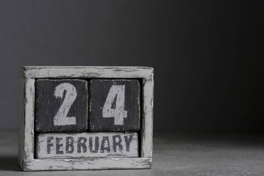 February 24 on wooden calendar, on dark gray background