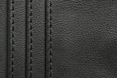 Arka plan siyah ipliklerle işlenmiş siyah deriden yapılır.