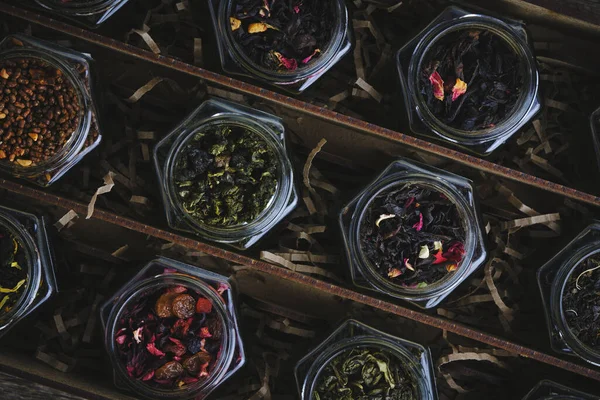 Set of various leaf tea packaged in jars. Black and green healthy tea with fruits, berries and herbs