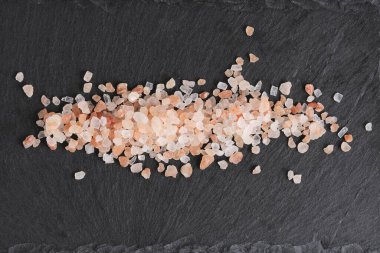 Arka planda, yenilebilir pembe Himalaya tuzu kristalleri.