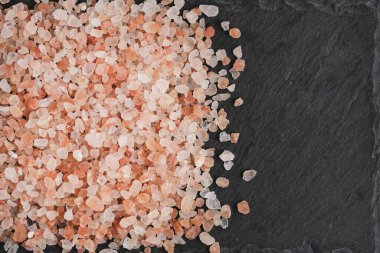 Arka planda, yenilebilir pembe Himalaya tuzu kristalleri.