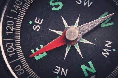 Yakın planda pusulayı çevir, ok doğu yönünü gösterir.