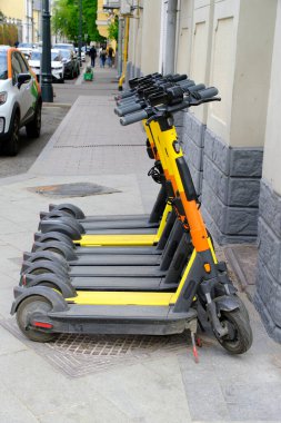 Şehir kaldırımlarında bir sürü elektrikli scooter bulunmakta, uygun, yeşil ulaşım talebine hizmet vermektedir.