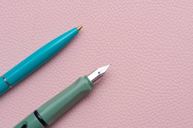 Pembe arka planda dolmakalem ve dolma kalemler