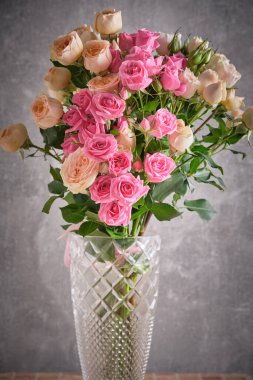 Gri arka planda pembe ve beyaz gül buketi