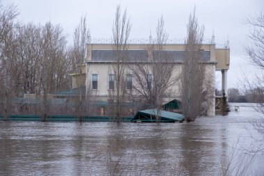İlkbahar seli sırasında nehir kıyısındaki evleri su bastı.