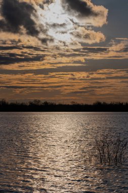 Gölün üzerinde güzel bir gün batımı. Bulutlu güzel gökyüzü