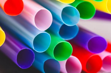 Siyah arka planda renkli pipetler. Kapat.