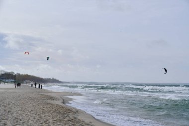 Fırtına sırasında kumsal bulutlu bir günde uçurtmacılar